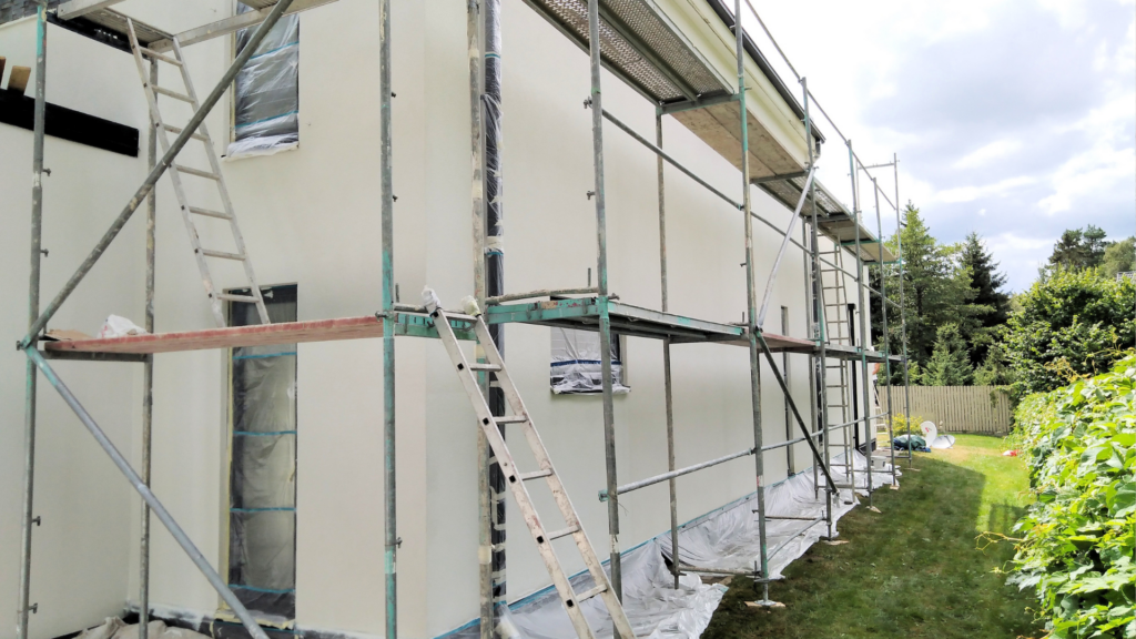 Hausfassade streichen: Ein frisch gestrichenes Haus mit einem Gerüst.